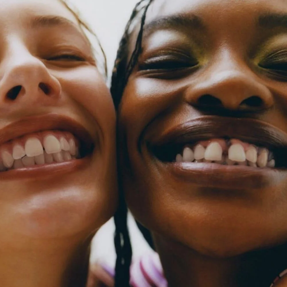 Two women smiling together showing bright happy smiles